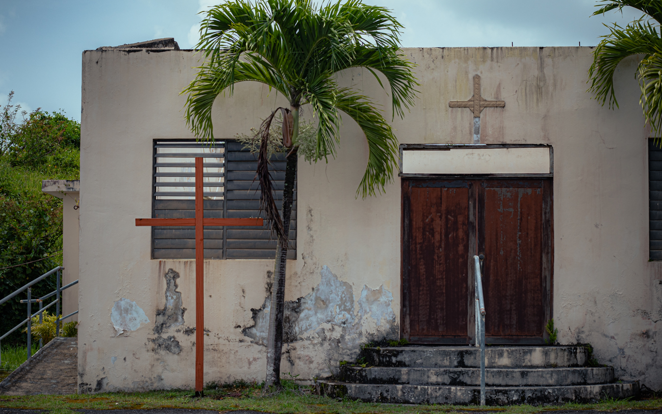 Wide shot of abandoned church facade with cross