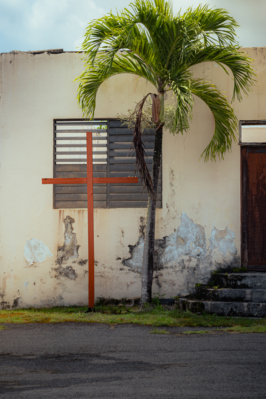 Close-up detail of weathered cross against wall